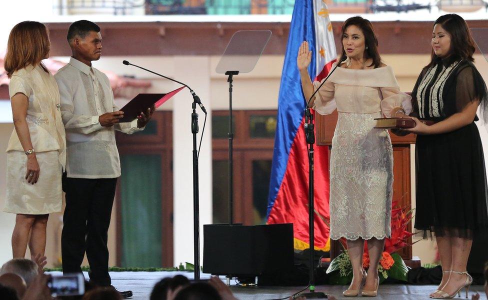 Philippine Vice President Leni Robredo, second right, is sworn in by village chiefs Ronaldo Coner and Regina Celeste during her inauguration ceremony in Quezon City, north of Manila on 30 June 2016.