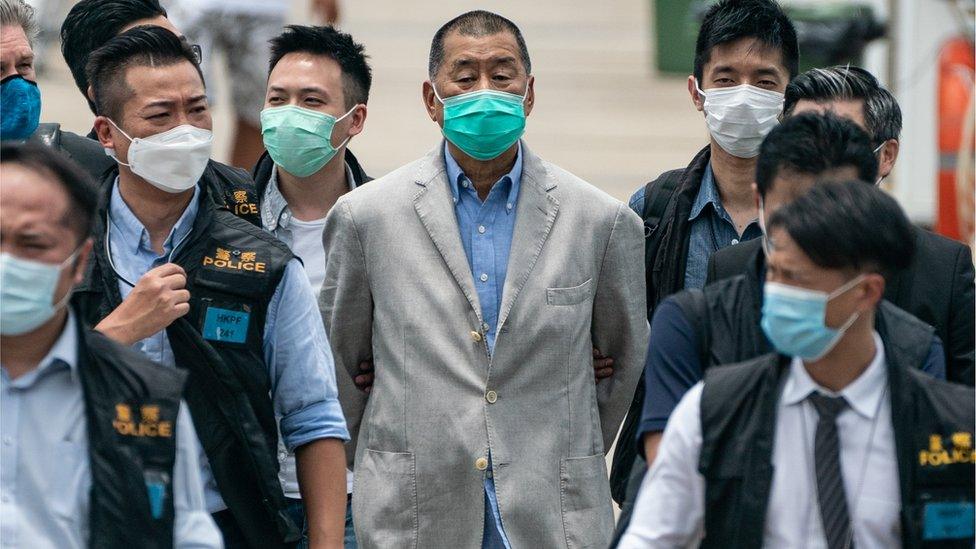 A handcuffed Jimmy Lai is escorted by Hong Kong police