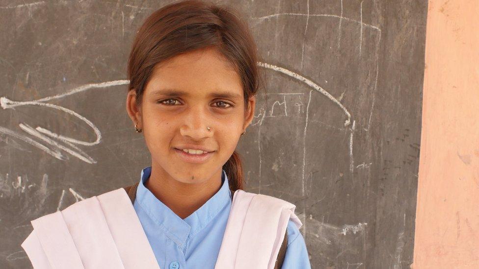 Bhagwanti in school uniform in front of a blackboard