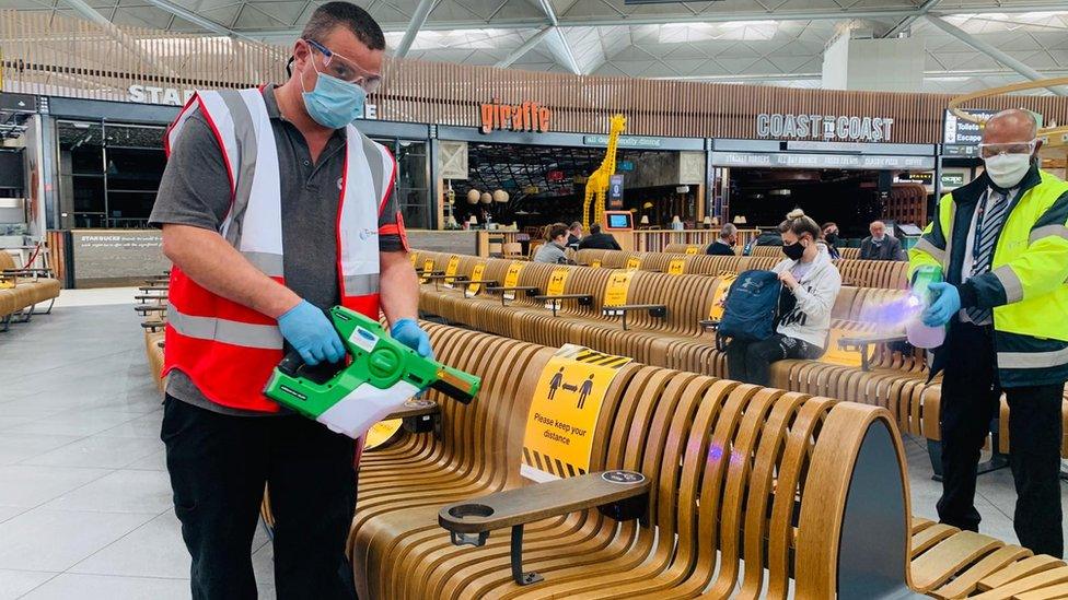 Masked men disinfect seats