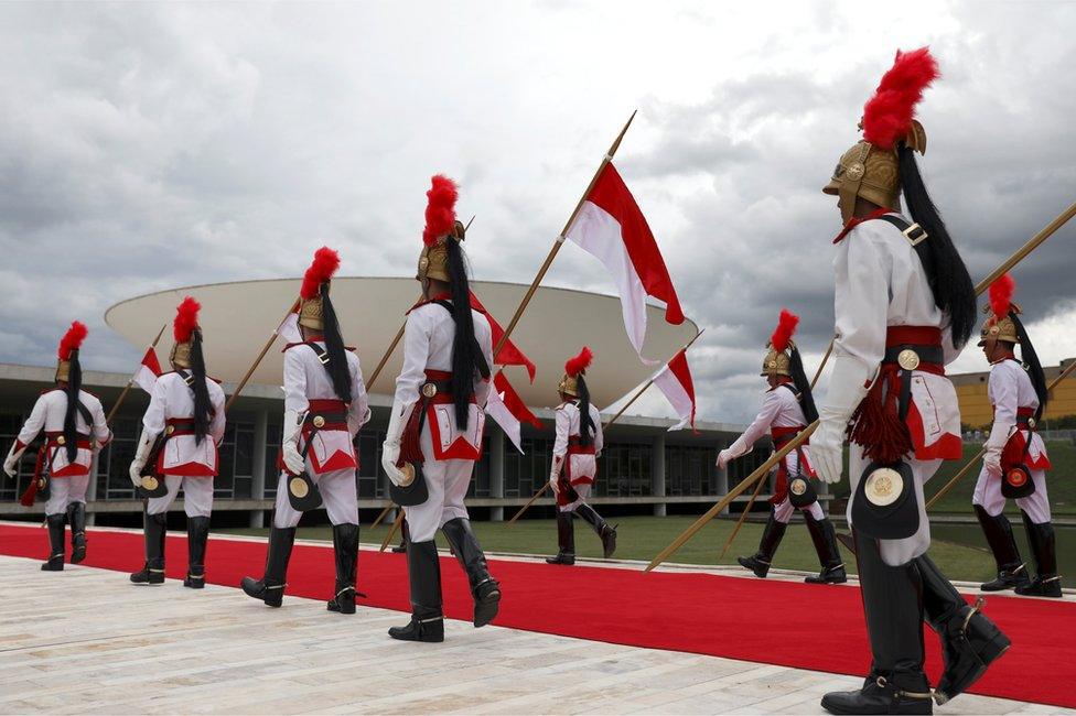 Official guards walk outside the Congress ahead of the inauguration, 1 January