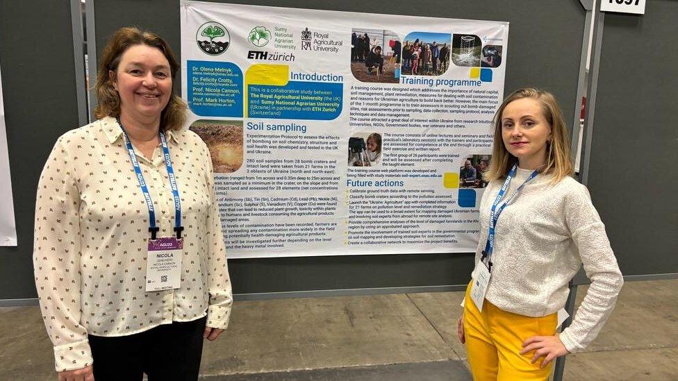 Prof Cannon and Prof Melnyk in front of a display board, one on either side