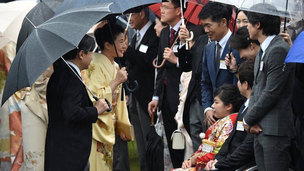 Japan's Crown Prince Naruhito and Crown Princess Masako greet guests during an autumn garden party at Akasaka Palace Imperial garden in Tokyo