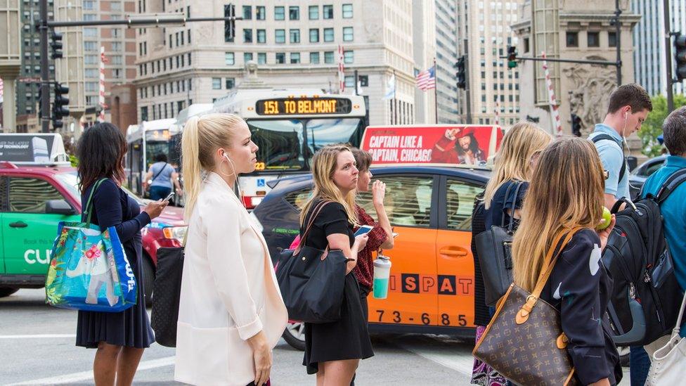 Commuters in Chicago wait for a bus