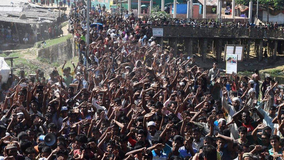 Hundreds of refugees protesting with their hands in the air