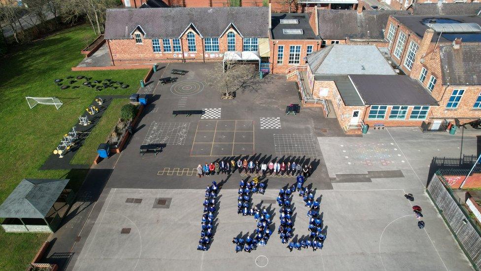 Pupils spelling out 150 in the playground of Alfred Street Junior School