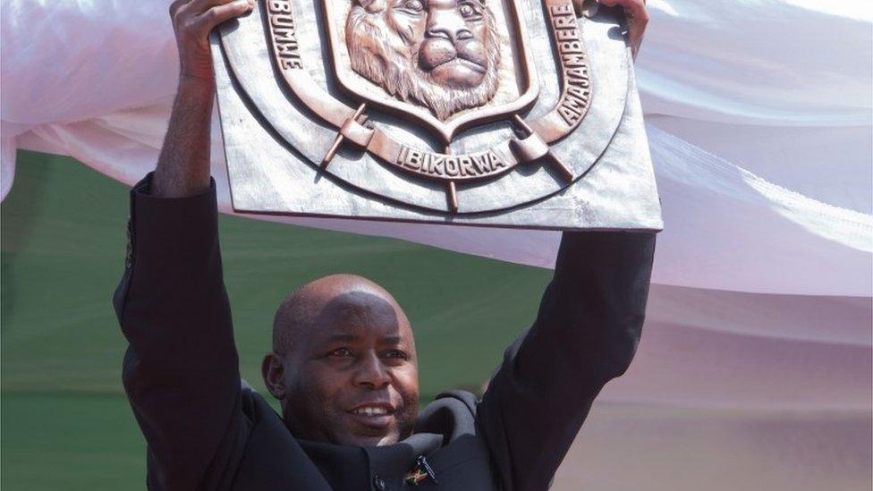 Evariste Ndayishimiye, Burundi"s elected President from the ruling party, the National Council for the Defense of Democracy - Forces for the Defense of Democracy (CNDD-FDD), holds the plate of the national symbol during the swearing-in ceremony at Ingoma stadium in Gitega, Burundi, on June 18, 2020.