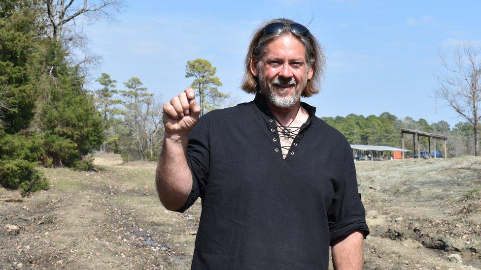 David Anderson holds up his pea-sized diamond