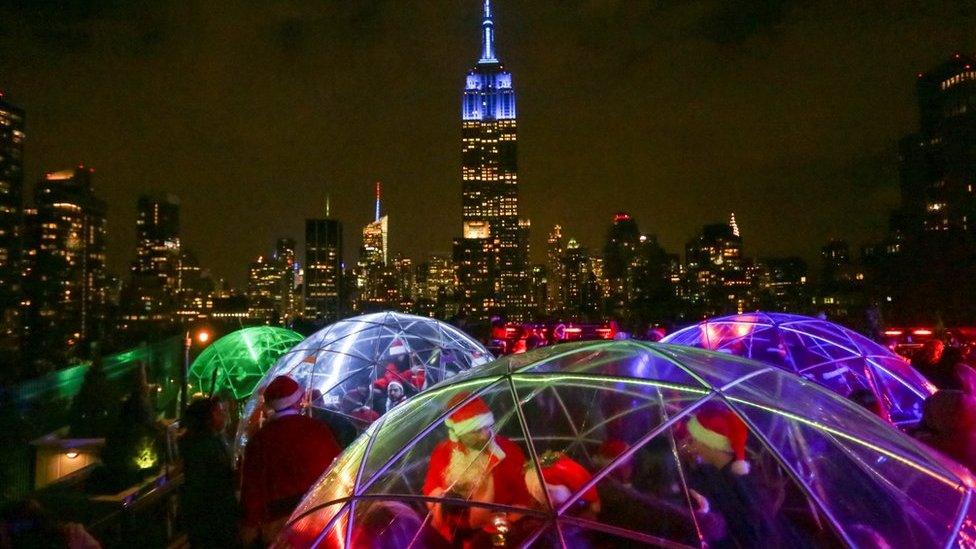 The Empire State Building is seen in the background as revellers take part in the annual SantaCon event in Manhattan, New York, December 10, 2016