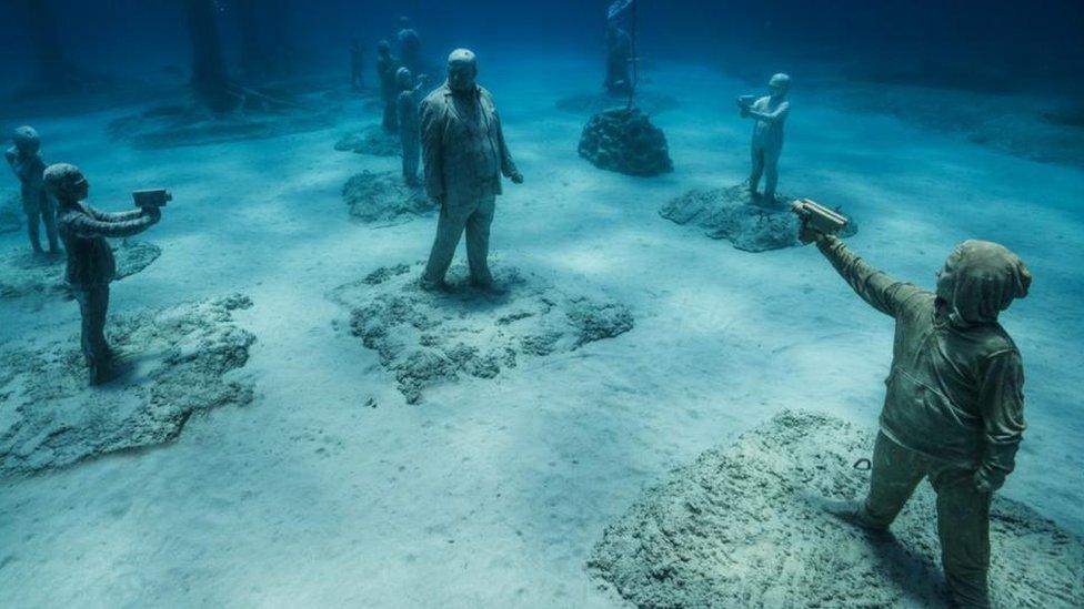 child sculptures in the ocean.