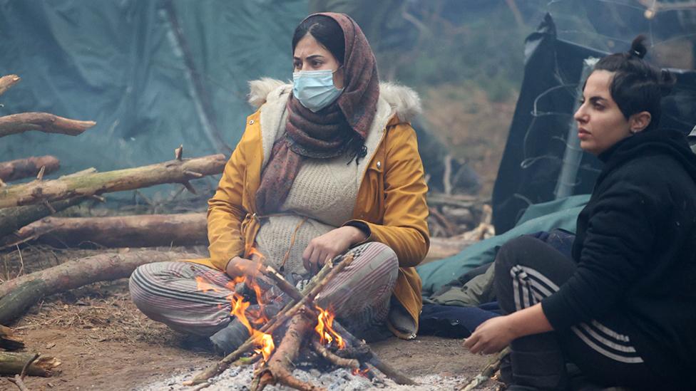 Migrants sit by the fire near Belarus' checkpoint of Bruzgi near the Polish border. Photo: 11 November 2021