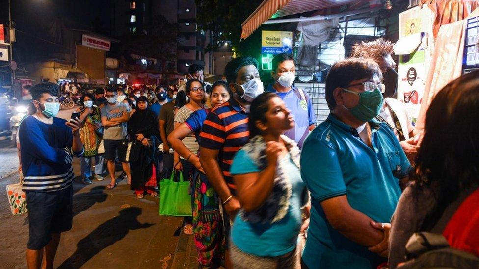 People line up outside a store in Mumbai on March 24, 2020.