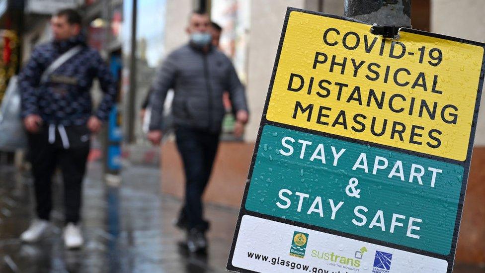 shoppers passing safety sign