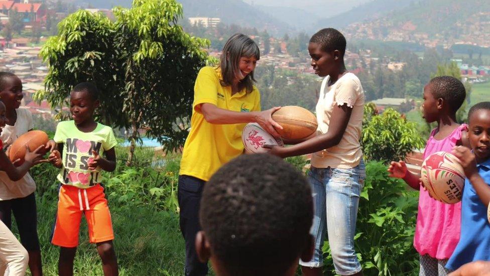 Mary Watkins giving out rugby kit to Rwandan children