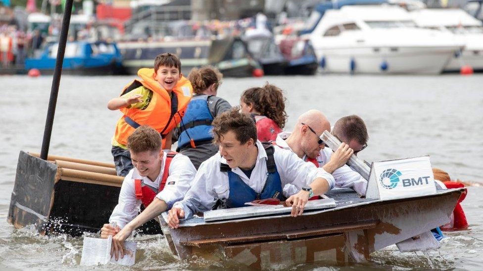 A group racing in last year's competition - they are directing a carboard boat in the harbour