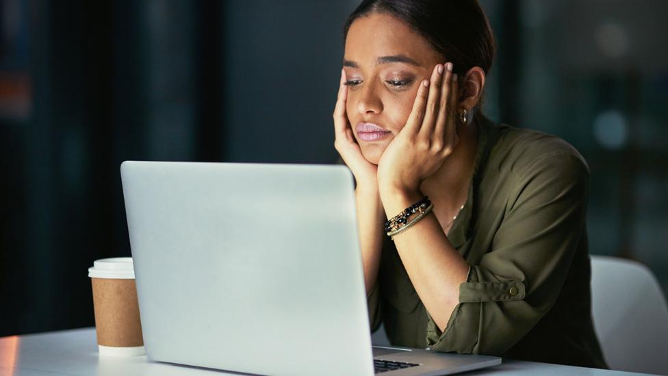 A woman looking at a laptop