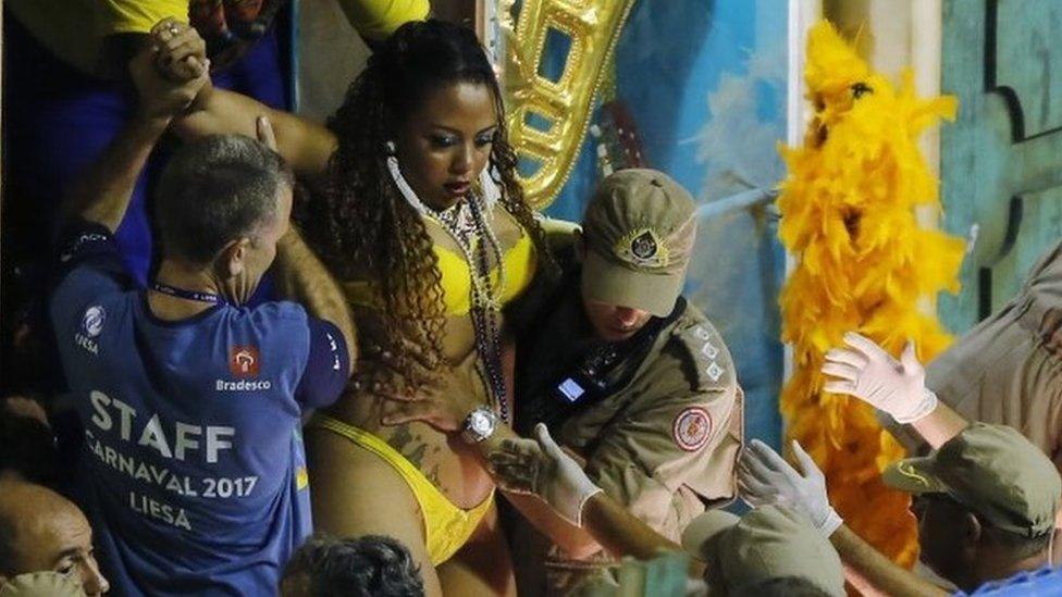 Firefighters and carnival staff carry a woman out of a float after an accident during the performing of the Unidos da Tijuca samba school for the Carnival celebrations at the Sambadrome in Rio de Janeiro, Brazil, Tuesday, Feb. 28, 201