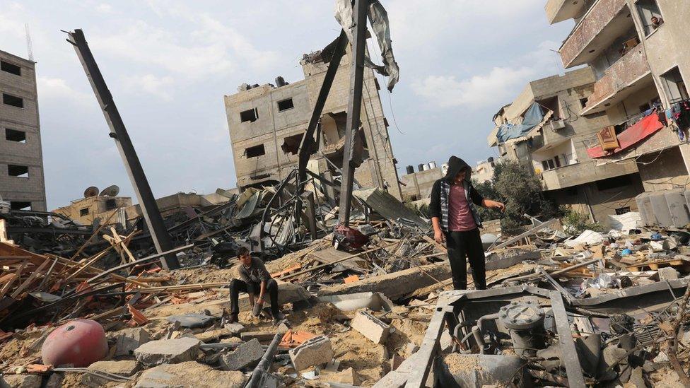 A Palestinian inspects the remain of a building that housed Hamas's Al-Aqsa TV channel