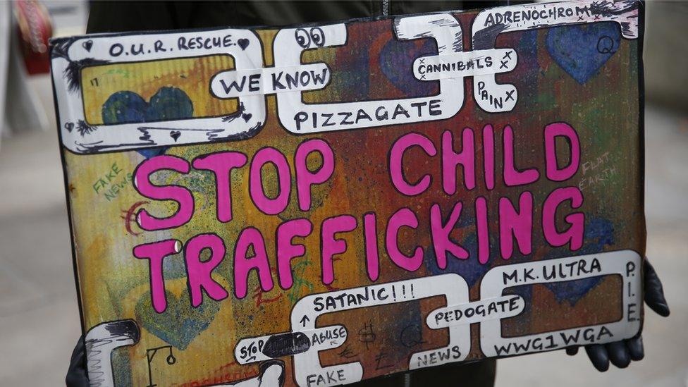 A protestor holds a sign during a "Save our Children" rally outside Downing Street on October 10, 2020 in London