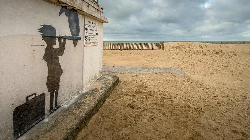 Artwork by British artist Banksy showing a child with a suitcase looking through a telescope with a vulture perched on it in Calais