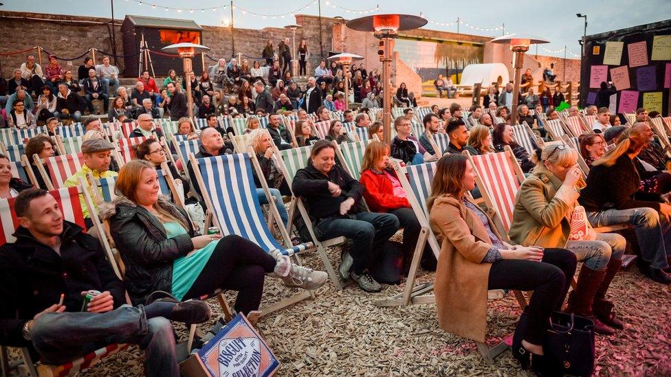 Crowds gather to watch an evening of comedy at Banksy's Dismaland theme park in Weston-super-Mare