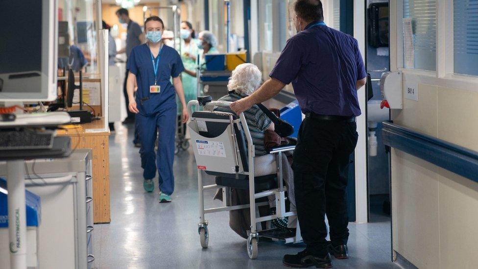 A patient on a hospital ward with medical staff