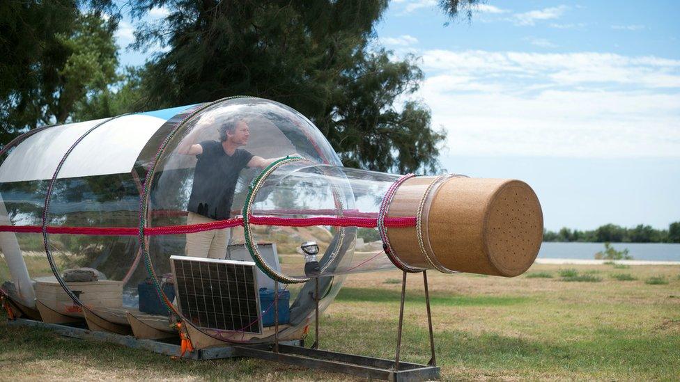 French artist Abraham Poincheval stands in a giant bottle during his performance The Bottle' 30 July 2015 in Port-Saint-Louis-du-Rhône, southern France