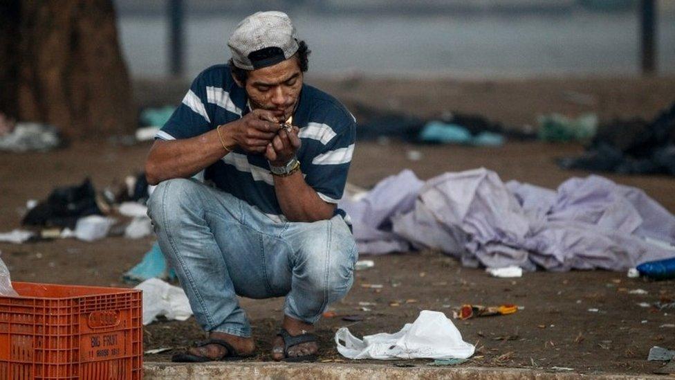 A drug addict uses crack cocaine during a police operation to dismantle drug points of sale in "Cracolandia", 11 June 2017.