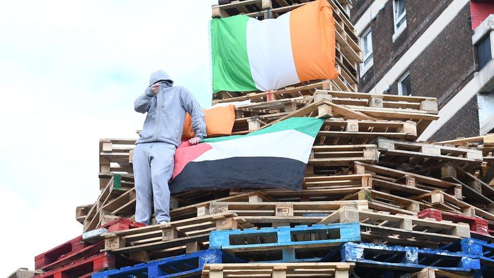 Youth on top of New Lodge bonfire