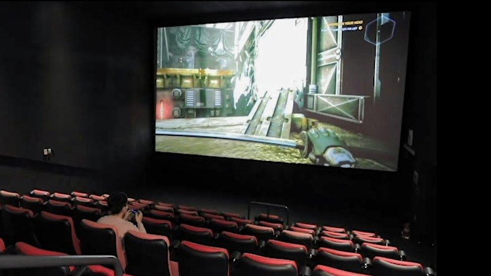 A young man playing computer games in a CGV cinema in South Korea