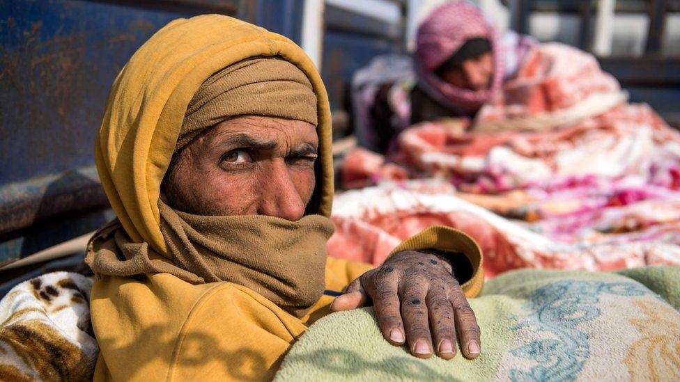 Civilians who fled from the embattled Baghouz area in the eastern Syrian province of Deir Ezzor sit in a truck