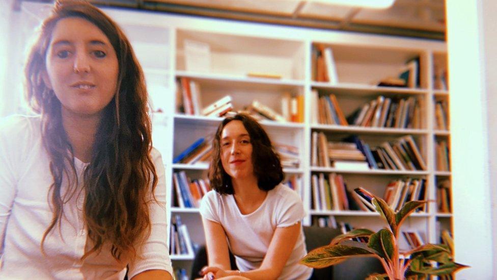 Bryony Ball and Meggan Baker looking at the camera in front of bookshelves