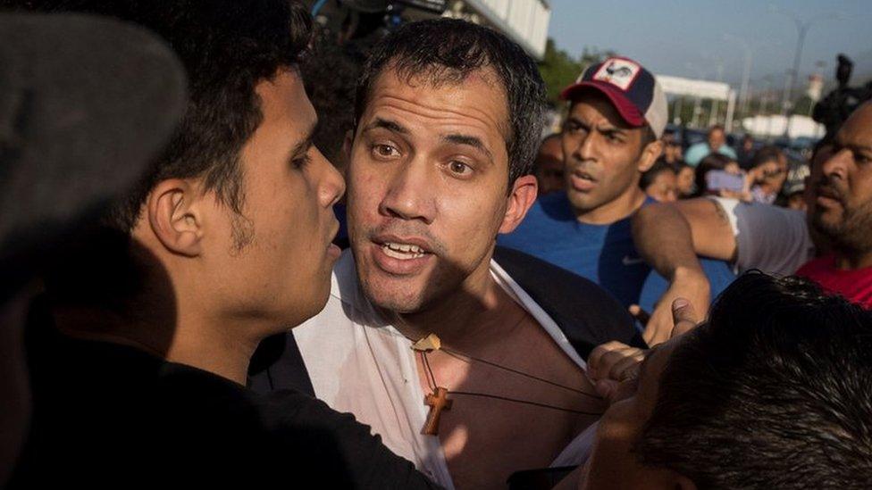 Guaidó arriving at the airport, having his shirt grabbed by protesters