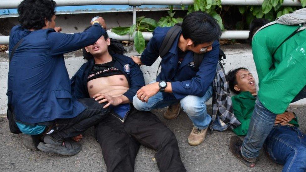 Students tend their injured friends during protests in Jakarta