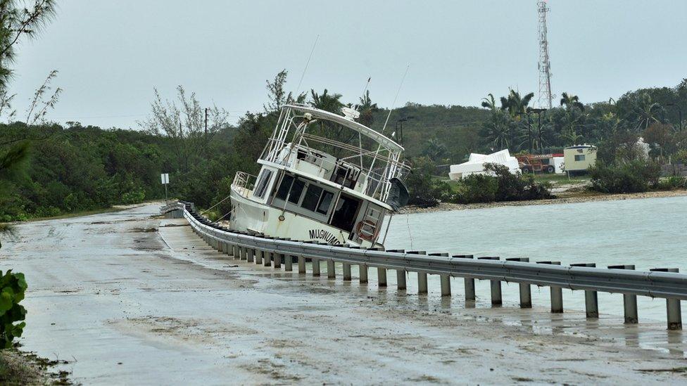 A boat sits washed up along the shore after breaking free of its mooring in the aftermath of Hurricane Matthew on the island of Exuma