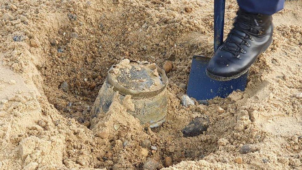 The bucket being dug out of Sizewell beach with a spade