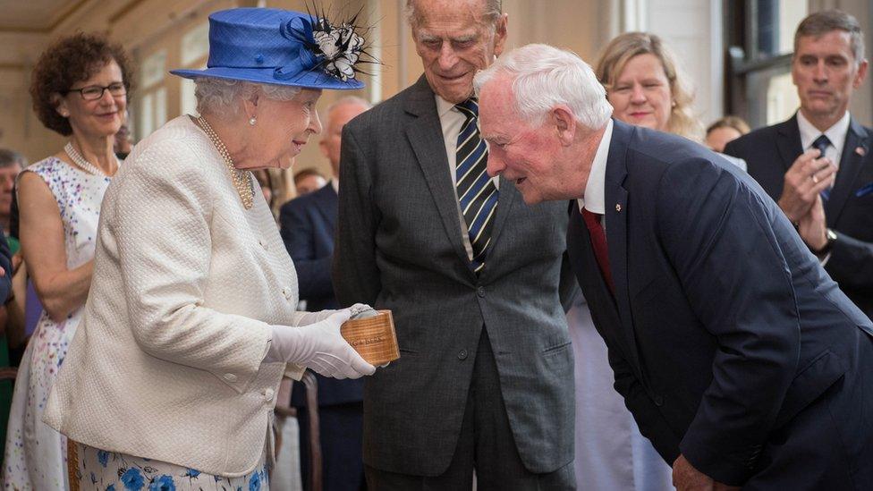 Britain's Queen Elizabeth II, accompanied by Britain's Prince Philip, Duke of Edinburgh, is welcomed by Canada Governor General David Johnston on a visit to Canada House in central London