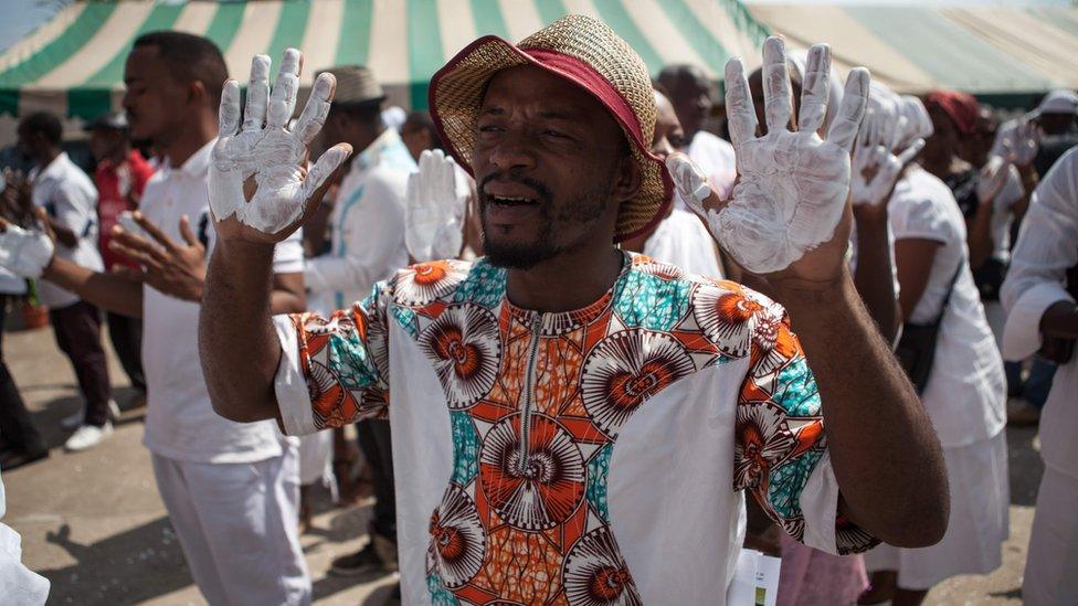 Supporters of the Gabonese opposition leader Jean Ping, dressed in white and with their hands painted in white as a sign of peace, take part in a commemoration march outside the party's headquarters in Libreville, Gabon - Saturday 10 September 2016