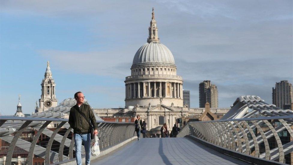 Commuter crosses a near-empty Millennium Bridge