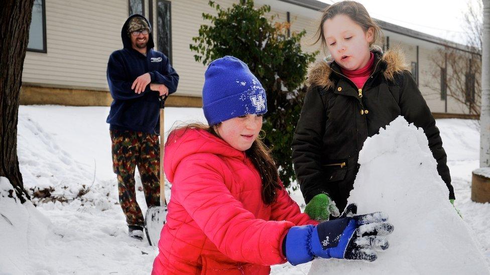 Ella and her sister Maddie making a snowman in Washington DC.