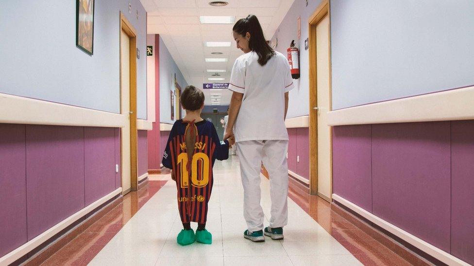 Boy wears football shirt hospital gown