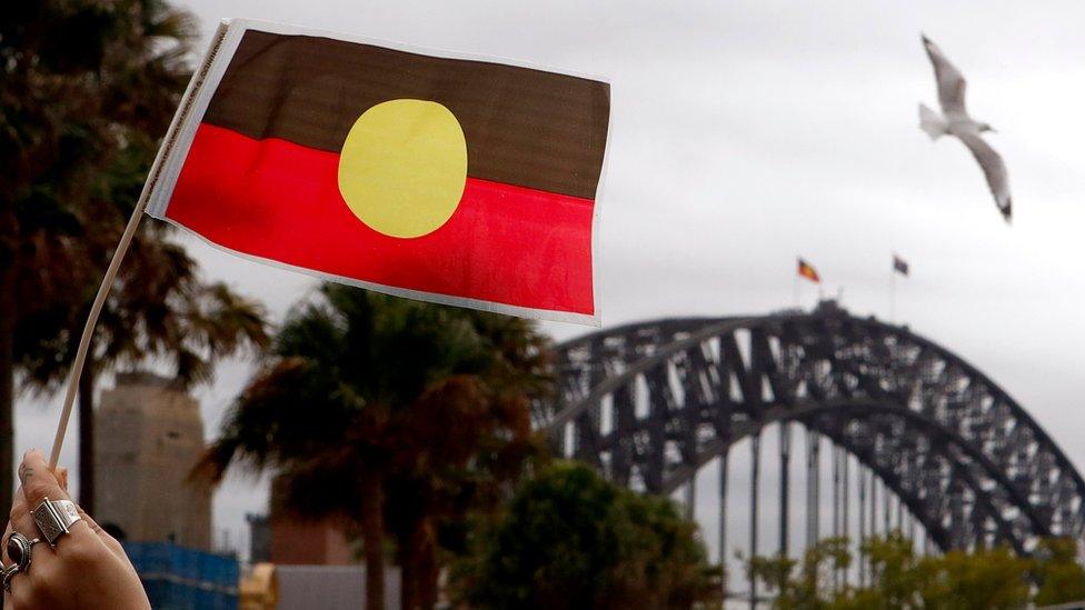 An Aboriginal flag in front of the Sydney Harbour Bridge