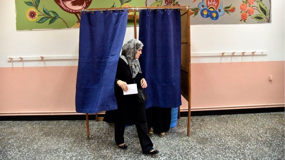 A woman leaves the polling booth during the local elections in Algeria