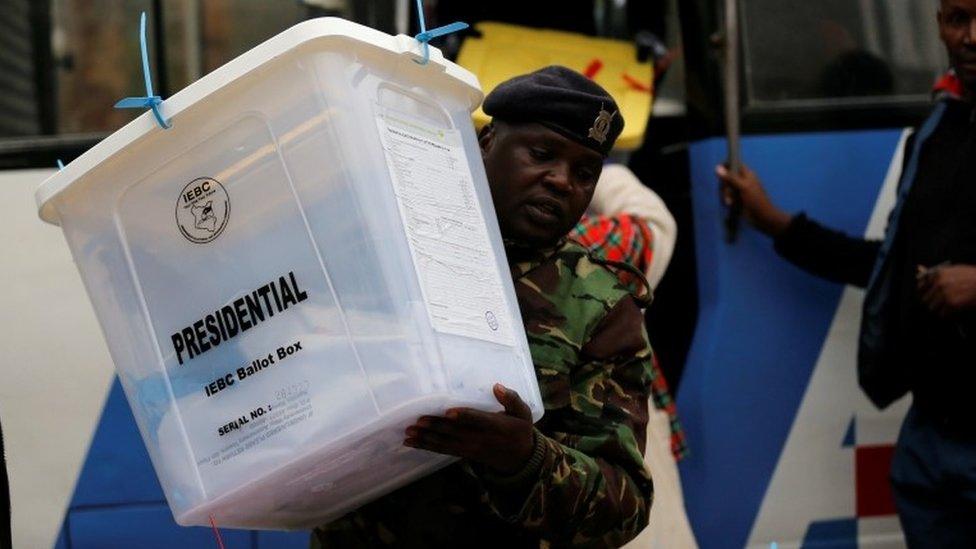 A security policeman unloads sealed ballot boxes from a bus to the Jamuhuri High School tallying centre in Nairobi, Kenya, 9 August 2017