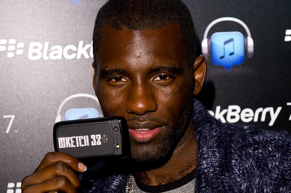 Wretch 32 with his Blackberry phone