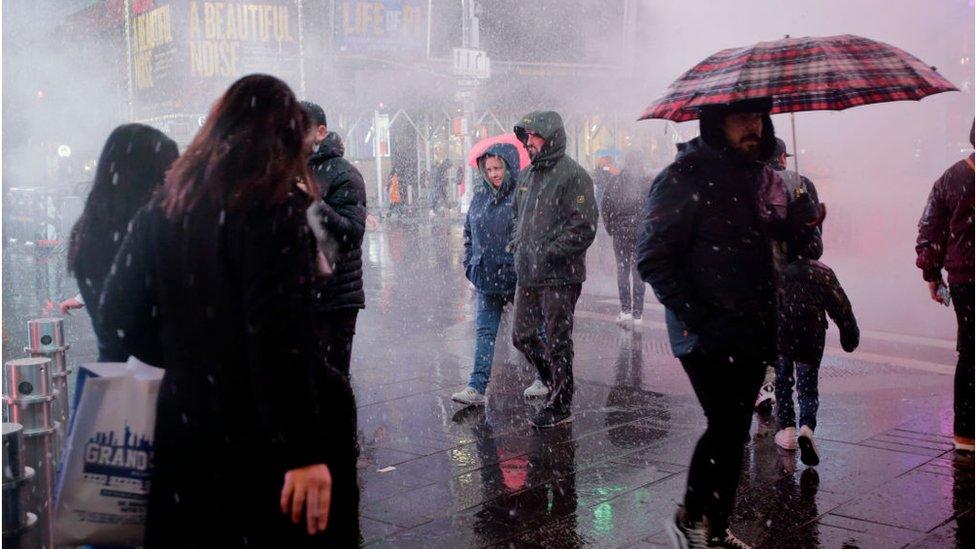 People visit Times Square during a snowfall on February 27, 2023 in New York City