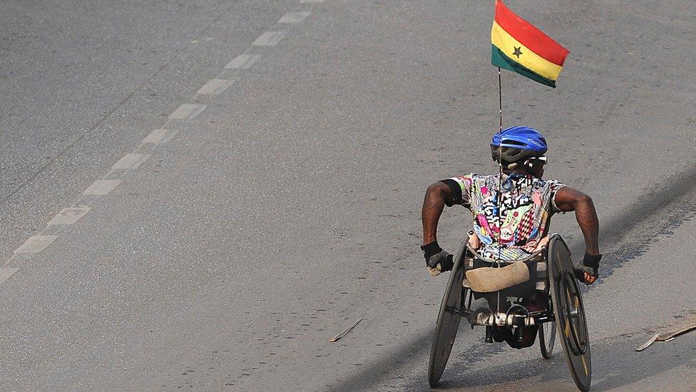 A man pushing his wheelchair in Ghana