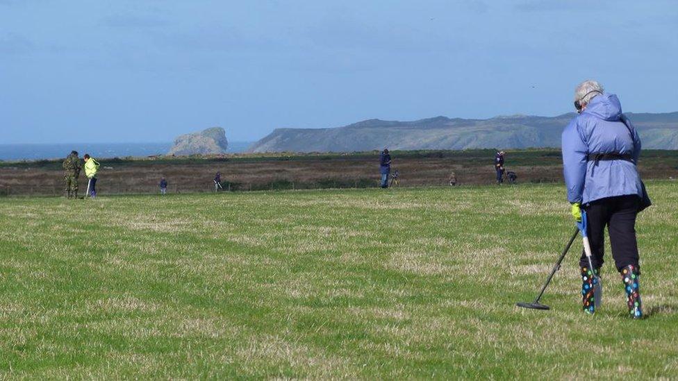 Metal detectorists in a field