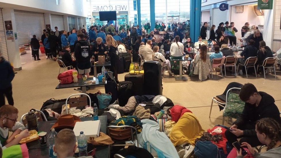 Passengers milling around and camped on the floor of a service station in Folkestone