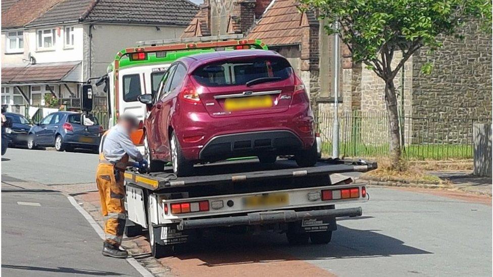 A burgundy Ford Fiesta on the back of a lorry